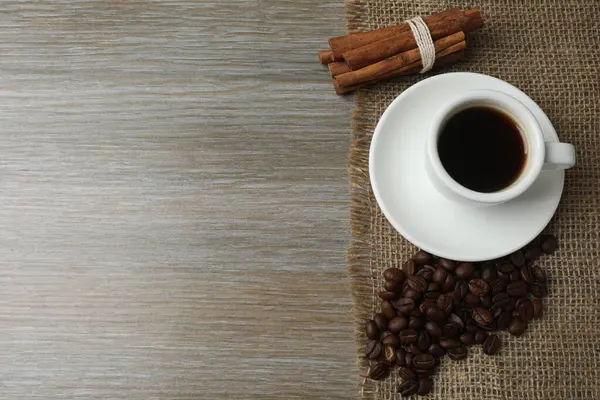 Ahşap arka planda tarçınlı kahve çekirdekleri.