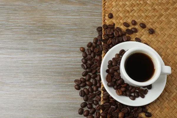 ahşap zemin üzerinde kahve çekirdekleri ile kahve