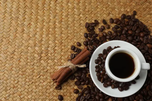 Kahverengi masada bir fincan kahve ve tarçın..