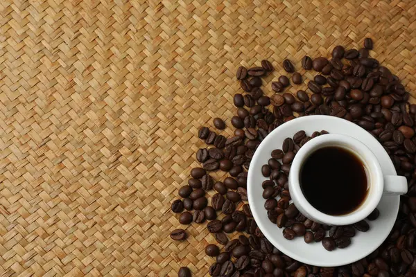 Beyaz arka planda kahve fincanı ve kahve çekirdeği. Kopyalama alanı olan üst görünüm