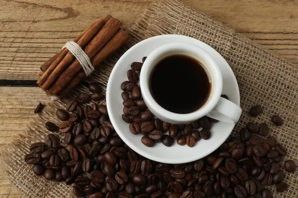 Kahve çekirdekleri, kahve fincanı ve tarçın çubuğu..