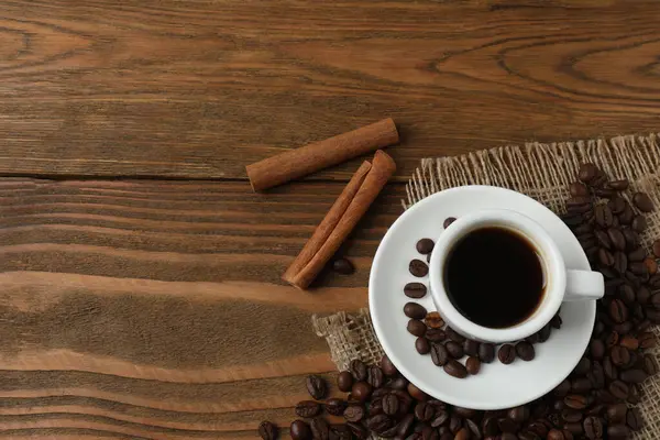 Tarçınlı bir fincan sıcak kahve ve ahşap arka planda anason. Boşluğu kopyala.