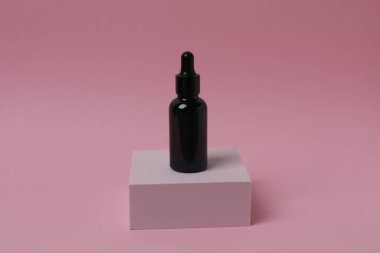 Renkli bir arka planda cam şişe ve damlatıcı. metin için boşluk kopyala.