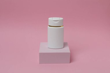 Pembe arka planda beyaz kozmetik ürünü. Boşluğu kopyala.