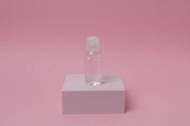 Pembe arka planda etiketi olan şişe.