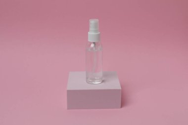 Pembe arka planda etiketi olan bir şişe parfüm.