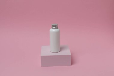 Pastel arka planda boş kozmetik şişesi.