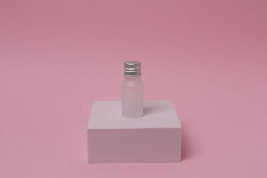 Pembe arka planda beyaz etiketli şişe..