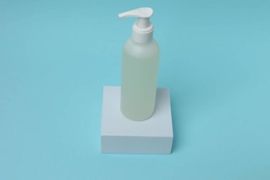 Mavi arka planda bir şişe kozmetik kremi..