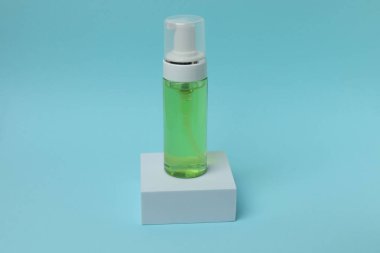 Yeşil arka planda damlatan şişe.