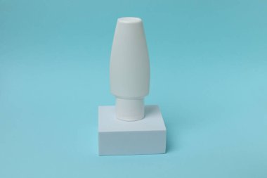 Açık mavi arka planda şeffaf bir kabın içindeki kozmetik krem. güzellik, cilt bakımı.