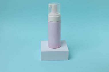 Pembe arka planda kozmetik şişesi