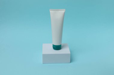 Mavi arkaplanda fotokopi alanı olan kozmetik şişe maketi.