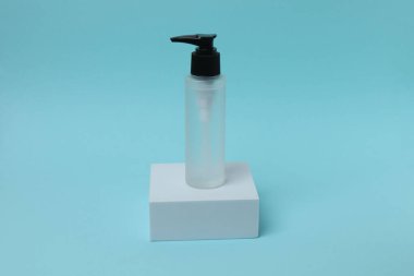 Mavi arka planda kozmetik şişesi