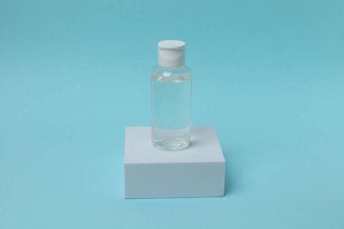 Cam parfüm şişesi. Mavi arka planda bir şişe parfüm..