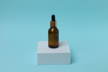 Mavi pastel arka planda damlatan cam şişe. asgari kavram.