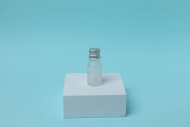 Açık mavi arka planda bir şişe şarap ve bir kadeh şarap. asgari kavram.