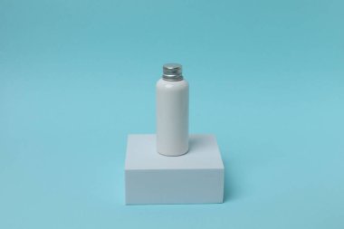 Mavi arka planda kozmetik şişesi