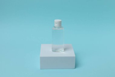 Fotokopi alanı olan mavi arkaplanda boş etiketli beyaz cam şişe..