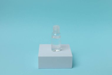 Beyaz etiketli şeffaf cam şişenin dikey görüntüsü.