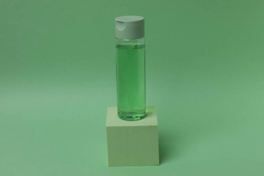 yeşil kozmetik şişe, yeşil arka planda izole.