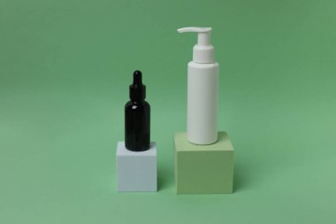 Yeşil arkaplandaki metin veya ürün için bir şişe kozmetik ürün ve boş etiket.