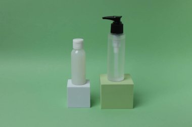 Serum için iki şişe beyaz ve siyah sıvı ve yeşil yapraklı bir pipetle yeşil ve sarı arka planda bir yer.