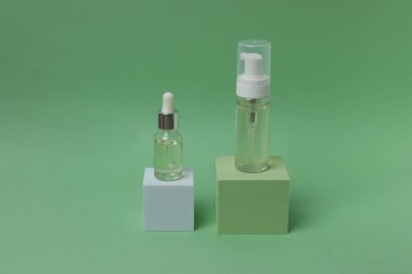 Renkli arka planda bir şişe serum, minimalizm.