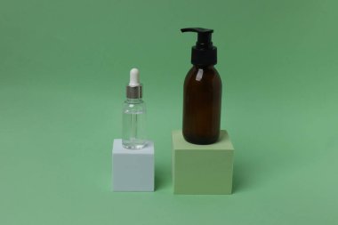 Yeşil zemin üzerinde serum olan bir şişe.