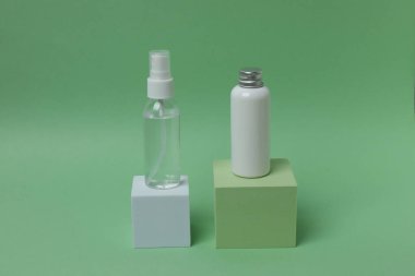 Mavi arka planda bir şişe serum, krema ve yeşil yaprak, minimalizm. minimalizm