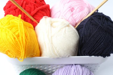 Örgü ipliği, beyaz ahşap masa üzerinde örgü iğneleri ve iğneler.