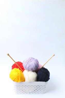 Beyaz arka planda iğnelerle örgü örmek için iplik.