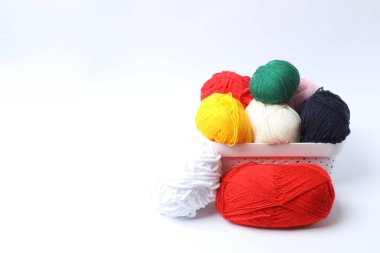 Beyaz bir arka planda örgü iğneleriyle örgü ipliği..