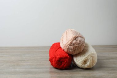 Ahşap arka planda kırmızı örgü ipliği. Örgü örmek için örgü iğneleri. Örgü hobisi.