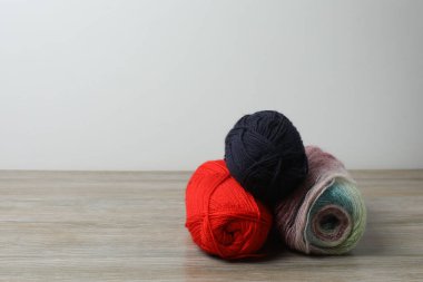 Ahşap bir masada örgü örmek için renkli iplik.