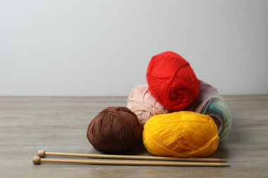 İplik yumağı ve beyaz tabakta örgü iğneleri. Örgü, şiş, örgü, iplik.