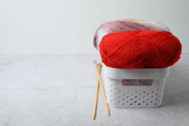 Beyaz kasede örgü iğneleri olan iplik..