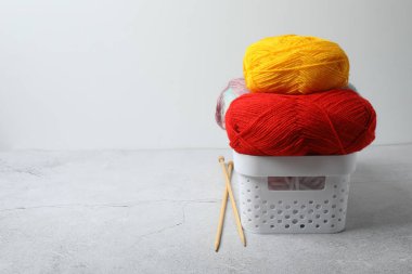 Örgü ve iğneler için kırmızı ve sarı iplikli bir sepet. Örgü hobisi.