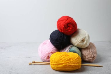 Masa arkasında renkli yün iplik ve örgü iğneleri