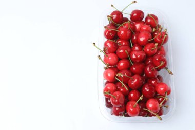 konteynırda beyaz bir arkaplanda kiraz