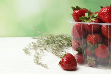 Konteynırdaki ahşap masada çilekler.