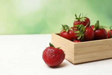 Konteynırdaki ahşap masada çilekler.