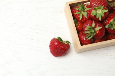 Konteynırdaki ahşap masada çilekler.