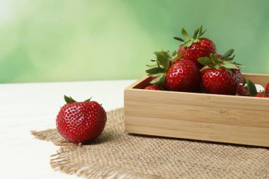 Konteynırdaki ahşap masada çilekler.