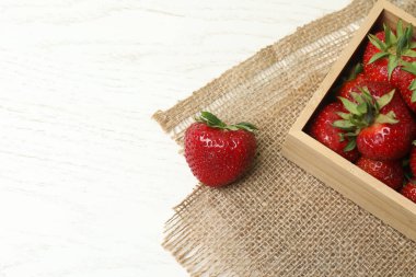 Konteynırdaki ahşap masada çilekler.