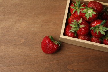 Konteynırdaki ahşap masada çilekler.