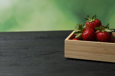Konteynırdaki ahşap masada çilekler.