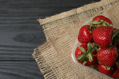 Konteynırdaki ahşap masada çilekler.