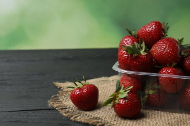 Konteynırdaki ahşap masada çilekler.