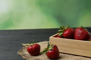 Konteynırdaki ahşap masada çilekler.